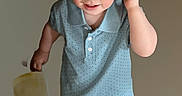 Conrad is registered to the contest to win money with this photo: blue_polo_shirt, boy, bucket, casual_clothing, child, curious, date_overlay, holding_object, indoor, light_background, phone_lock_screen, playful, portrait, shorts, single_person, smiling, sneakers, time_overlay, walking, young_child