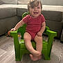 Iryis joined the competition — help win amazing prizes! baby, child, smiling, green_chair, curly_hair, indoor, living_room, sofa, wooden_floor, happy, person, toddler, red_onesie, plastic_chair, cute, sitting, furniture, playful, young_child, home
