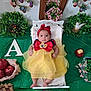 apple, baby, bed, blanket, child, costume, cute, decor, dress, fairy_tale, flower, fruit, greenery, headband, indoor, infant, portrait, red_bow, snow_white, yellow_dress