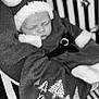 Presley is registered to the contest to win money with this photo: baby, sleeping, christmas, santa_hat, blanket, holiday, festive, black_and_white, cozy, infant, cute, portrait, clothing, face, peaceful, soft_texture, decorative, seasonal, child, resting