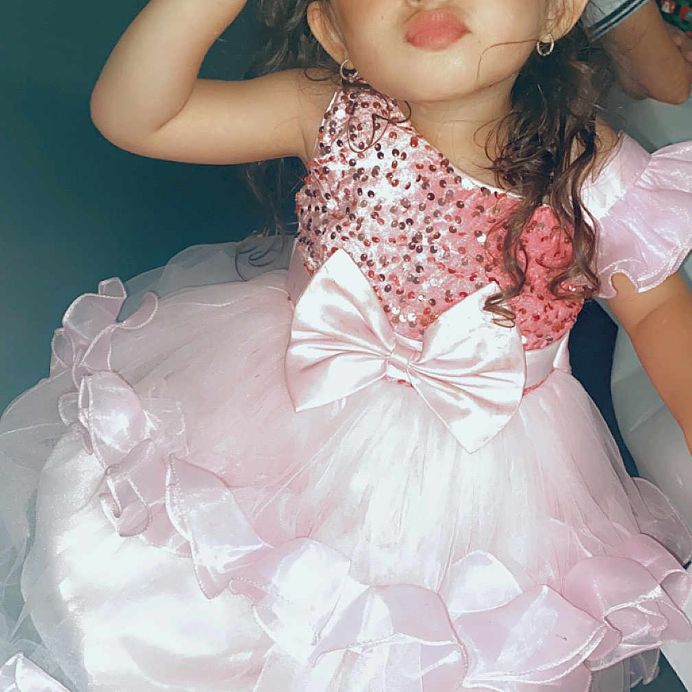 Keya a rejoint le concours — aidez-le/la à gagner de superbes lots ! bows, celebration, child, curly_hair, cute, dress, earrings, fashion, frilly, fun, girl, indoor, long_hair, peace_sign, person, pink, portrait, pose, smile, young