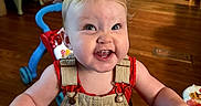 Nyx joined the competition — help win amazing prizes! toddler, smiling, child, indoor, wooden_floor, kitchen, walker, overalls, red_shirt, person, happy, face, eyes, hair, furniture, refrigerator, cabinet, barefoot, toy, home