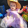 baby, child, purple_dress, hat, blue_eyes, toy, car_interior, sunlight, sitting, cute, infant, playful, colorful, clothing, footwear, person, portrait, summer, accessory, happy