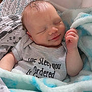 Ezra joined the competition — help win amazing prizes! baby, sleeping, blanket, onesie, smile, peaceful, infant, soft, cozy, cute, child, portrait, closeup, hand, face, skin, newborn, rest, relaxation, indoors