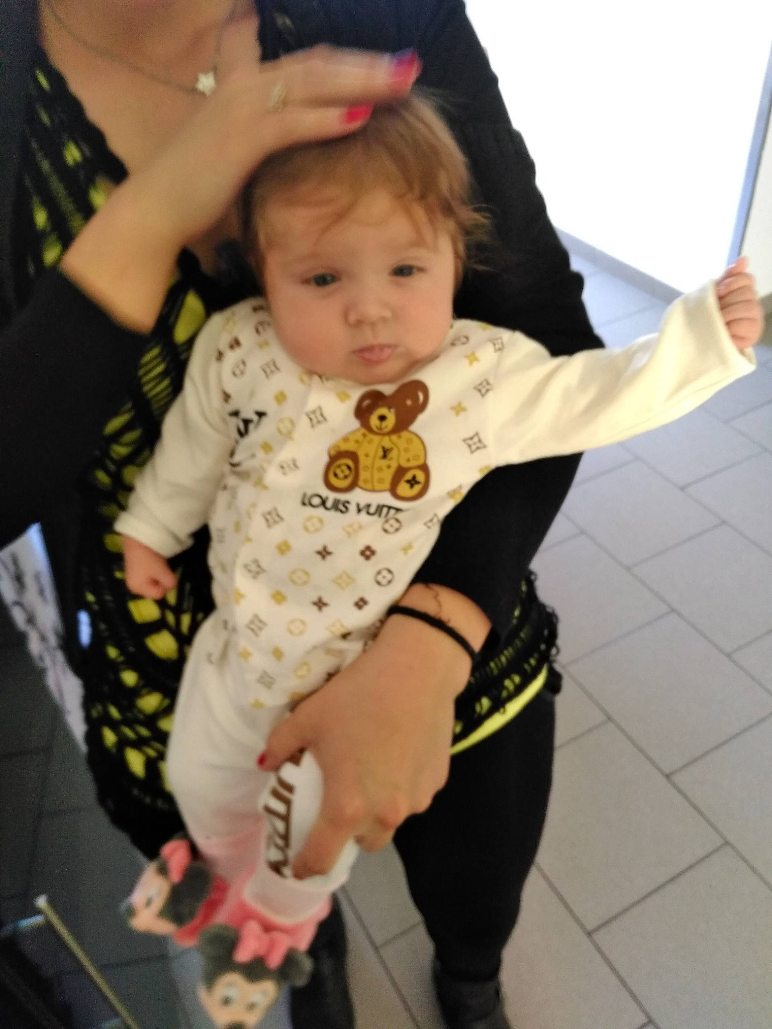 Melyana participe au concours pour gagner de l'argent avec cette photo : active_pants, arm, baby, baby_toddler_clothing, child, event, flooring, fun, gesture, hand, happy, joint, pattern, person, sitting, sleeve, sock, sweatpant, t_shirt, thumb