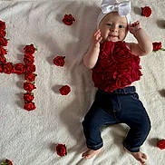 Mya participe au concours pour gagner de l'argent avec cette photo : baby, infant, child, red_roses, white_blanket, bow, headband, floral_top, dark_pants, barefoot, smiling, happy, portrait, laying_down, cute, celebration, flower_arrangement, soft_texture, indoor, closeup