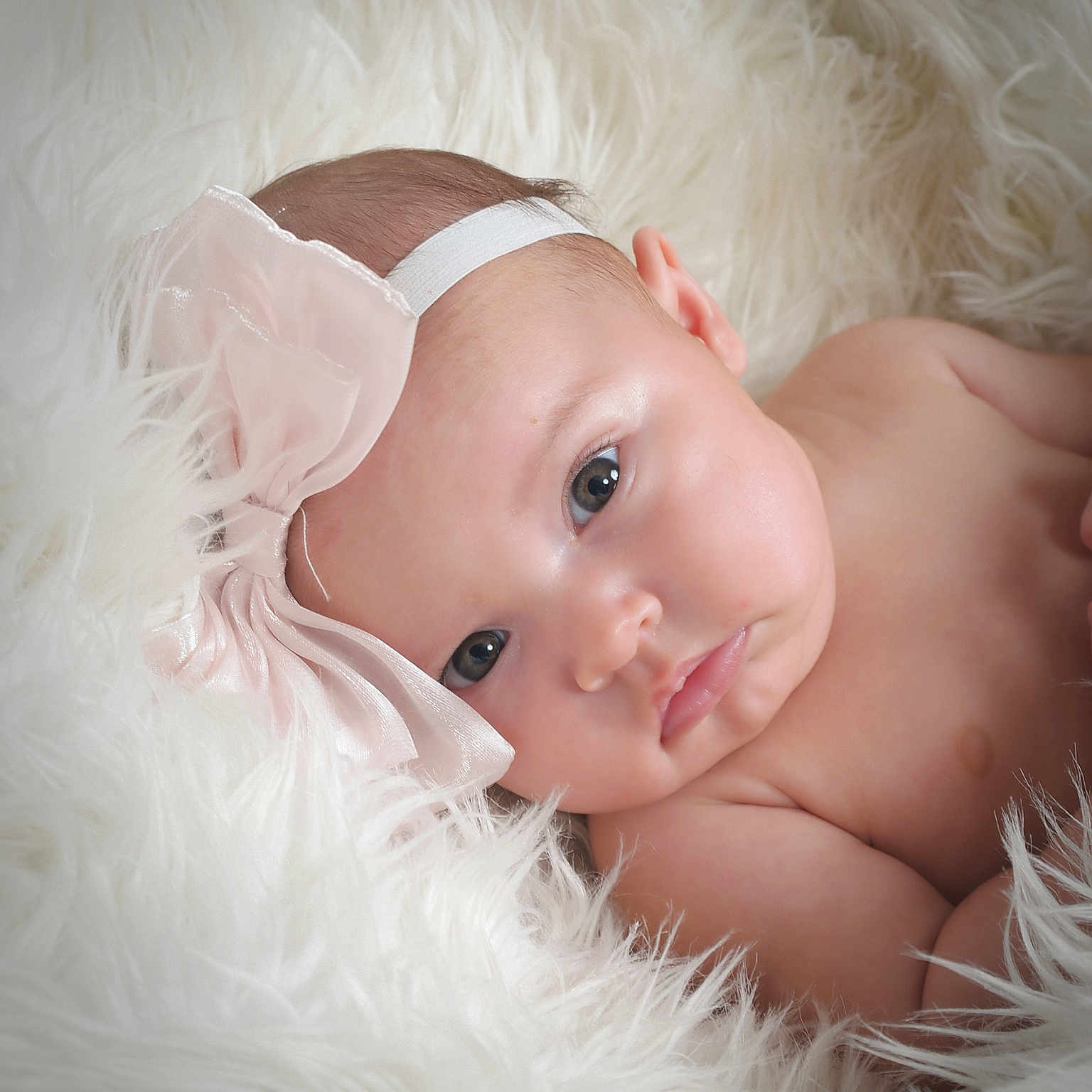 Roma is registered to the contest to win money with this photo: baby, infant, face, headband, bow, skin, closeup, portrait, lying_down, blanket, soft_texture, cute, expression, child, newborn, human, peaceful, indoors, adorable, resting