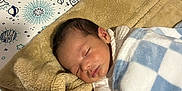 Eric is registered to the contest to win money with this photo: baby, sleeping, blanket, pillow, crib, infant, peaceful, resting, cozy, blue, white, checkered, tan, soft, cute, child, bed, nursery, indoors, peace