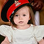 toddler, child, hat, military_hat, white_dress, portrait, face, curious, indoor, person, cute, young_child, fashion, costume, apparel, headwear, expression, closeup, soft_lighting, blurry_background