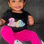 Naiayla is registered to the contest to win money with this photo: toddler, child, smiling, sitting, carpet, clothing, bow, sneakers, pink_leggings, black_tshirt, barbie_logo, happy, indoors, portrait, cute, young_child, feet, face, person, fashion