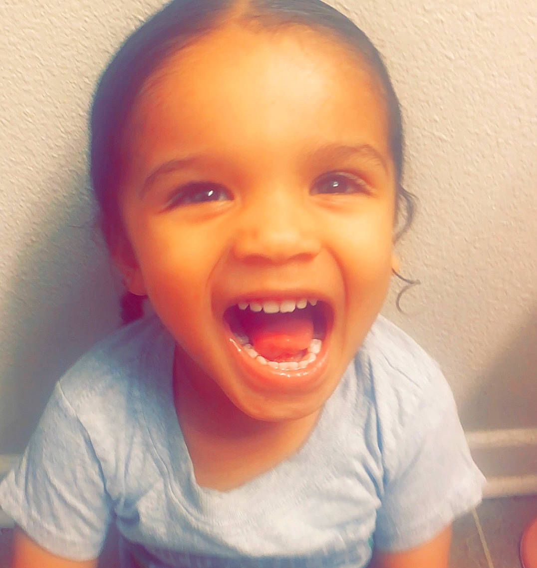 Christian is registered to the contest to win money with this photo: cheek, ear, eye, eyelash, fun, gesture, happy, human_body, iris, jaw, lip, mouth, nose, orange, person, smile, t_shirt, thumb, toddler, tongue