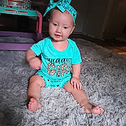Avery is registered to the contest to win money with this photo: baby, child, girl, blue_outfit, bow, sitting, carpet, indoor, cute, smile, furniture, television, floor, legs, feet, headband, person, portrait, happy, young_child