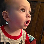 Harold is registered to the contest to win money with this photo: child, clothing, cute, ear, expression, eyes, face, head, indoor, light, mickey_mouse, mouth_open, person, portrait, shirt, sitting, skin, toddler, wooden_background, young