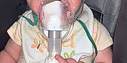 Ember joined the competition — help win amazing prizes! baby, breathing_mask, nebulizer, car_seat, bib, onesie, hand, face, wide_eyes, medical_device, infant, child, seatbelt, expression, indoor, cute, healthcare, person, plastic, closeup