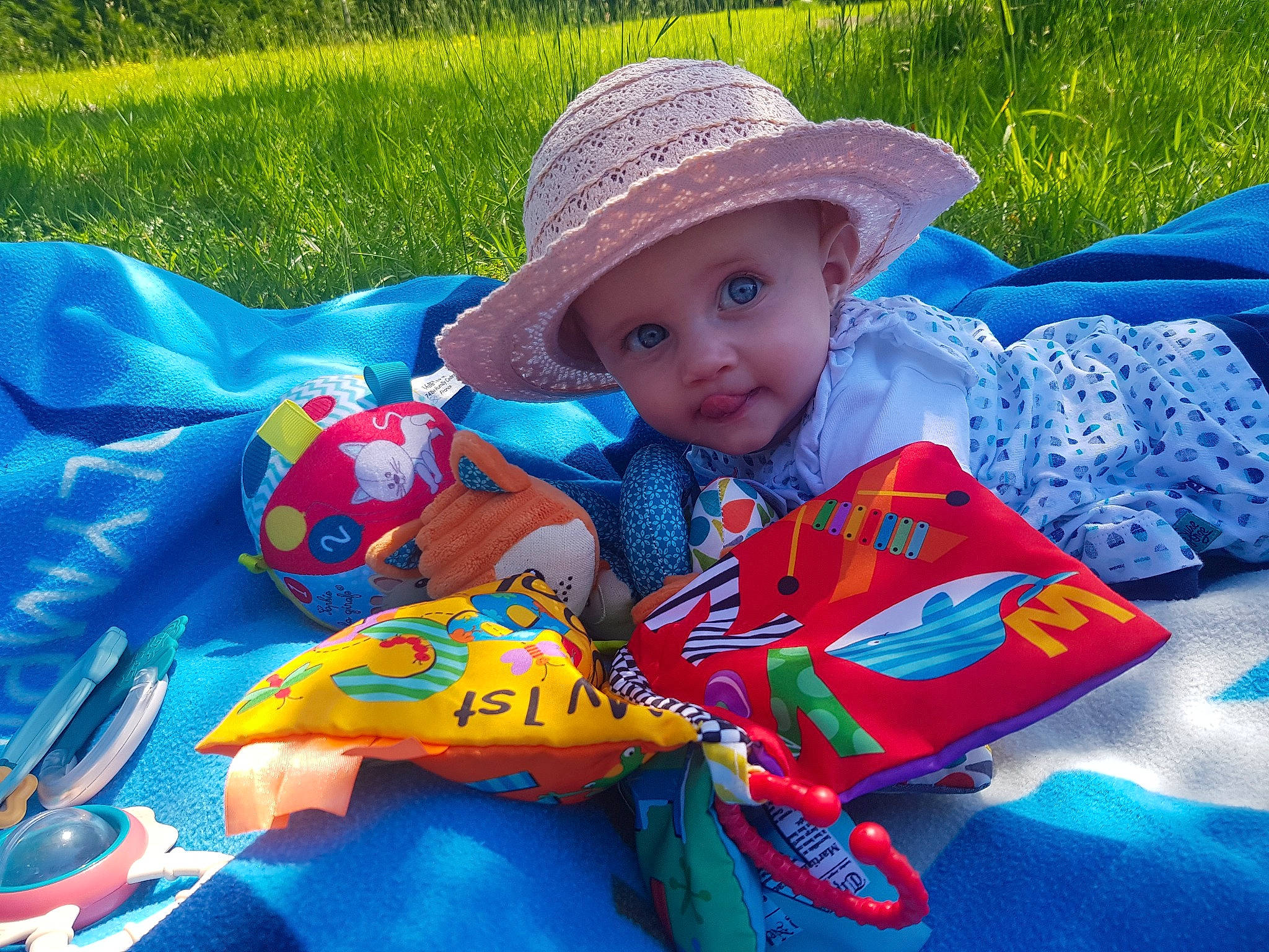 Lola participe au concours pour gagner de l'argent avec cette photo : baby_toddler_clothing, beauty, cap, child, fun, grass, grassland, happy, hat, headwear, leisure, people_in_nature, person, plant, play, recreation, sitting, summer, sun_hat, textile