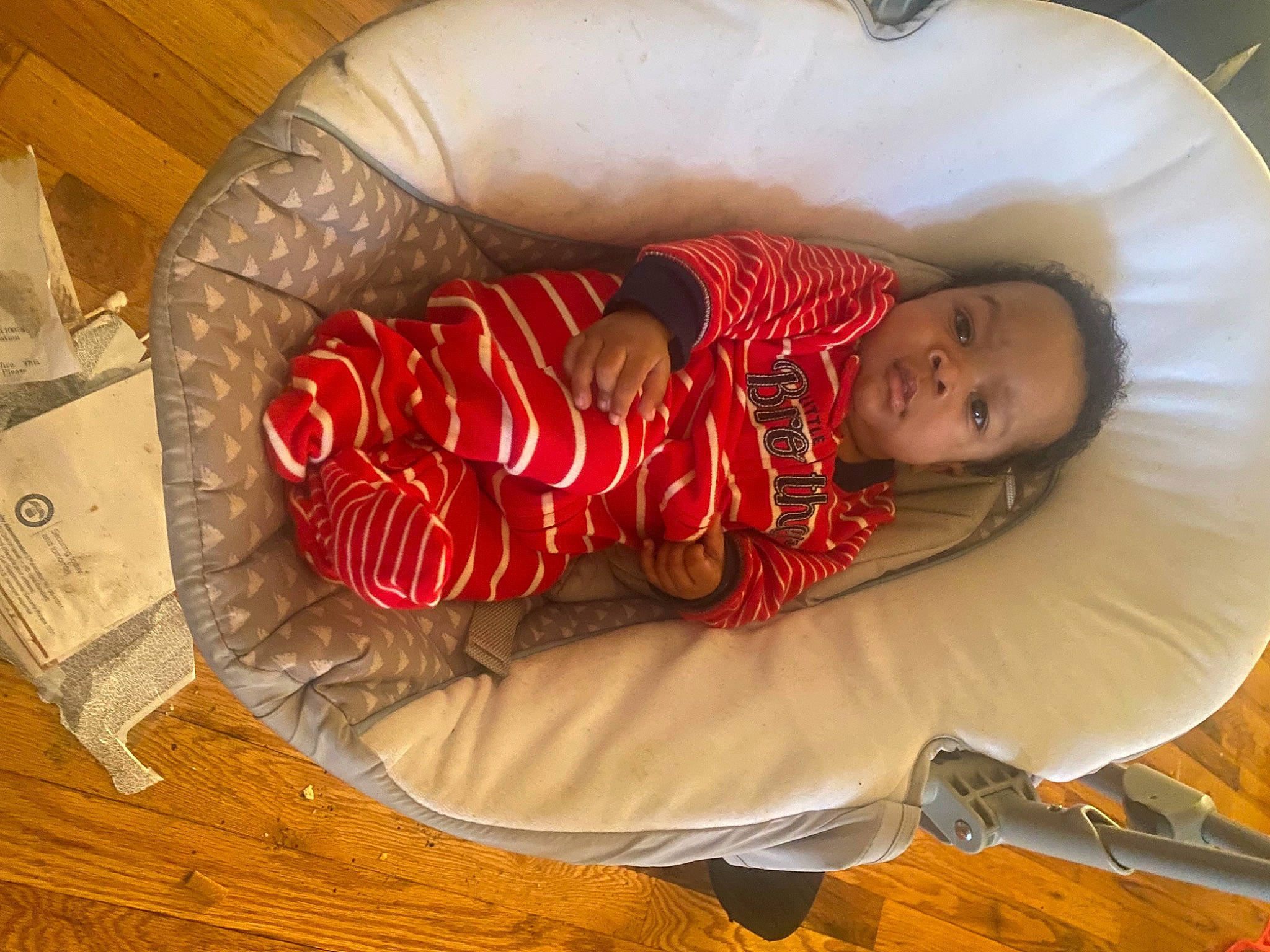 Prince is registered to the contest to win money with this photo: baby, baby_toddler_clothing, carmine, child, comfort, elbow, event, foot, happy, hardwood, holiday, human_body, human_leg, lap, leg, linens, person, room, sitting, toddler