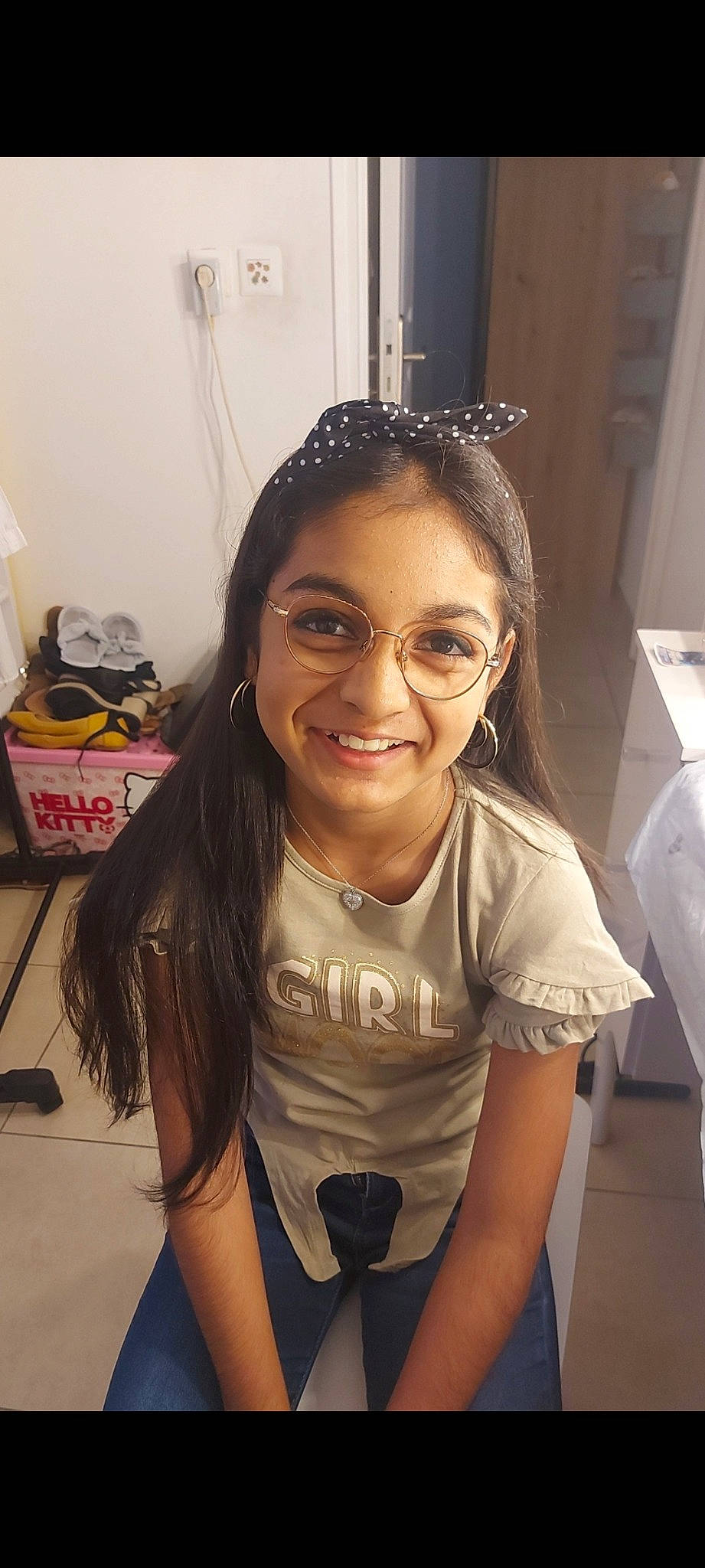 Aliya participe au concours pour gagner de l'argent avec cette photo : arm, black_hair, blond, chair, cool, eyebrow, eyewear, facial_expression, fun, glasses, hairstyle, happy, headpiece, joy, long_hair, necklace, person, room, sleeve, smile