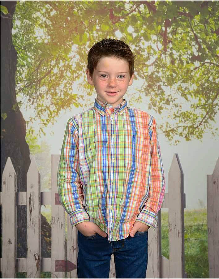 Adrian is registered to the contest to win money with this photo: blazer, child, collar, denim, dress_shirt, fence, formal_wear, fun, grass, happy, joy, leaf, neck, person, plaid, plant, sleeve, standing, street_fashion, tartan