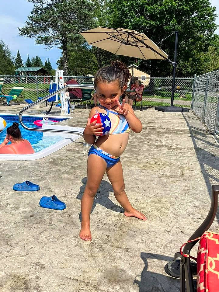 Meela is registered to the contest to win money with this photo: bag, barefoot, brassiere, fun, joy, leisure, luggage_and_bags, outdoor_furniture, people_on_beach, person, recreation, sand, shade, sky, swimsuit_top, swimwear, thigh, toddler, tree, umbrella