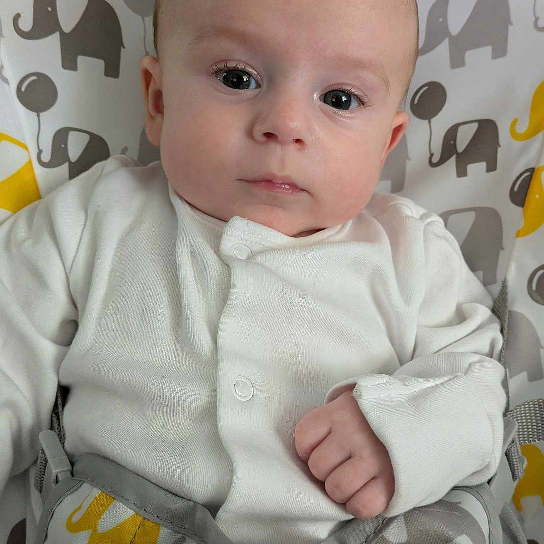 Chester is registered to the contest to win money with this photo: baby, blanket, bodypart, clothing, cushion, dress, face, finger, hand, happy, head, homedecor, longsleeve, newborn, pants, person, photography, portrait, shirt, sleeve