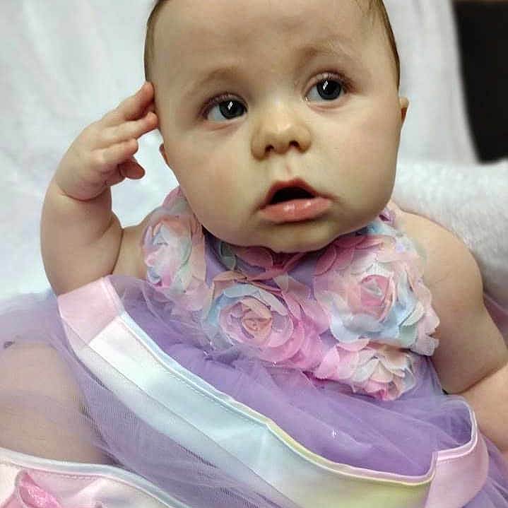 Raine joined the competition — help win amazing prizes! baby, biting, bodypart, clothing, cushion, dress, face, finger, hand, head, homedecor, newborn, person, photography, portrait, sitting, skin