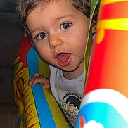 Mila a rejoint le concours — aidez-le/la à gagner de superbes lots ! toddler, child, face, blue_eyes, mouth_open, inflatable_toy, colorful, indoor, playful, happy, curly_hair, clothing, minnie_mouse, toy, bright_colors, closeup, person, young_child, expression, fun