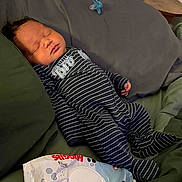 Lenoxx is registered to the contest to win money with this photo: baby, newborn, sleeping, onesie, striped_clothing, pacifier, huggies_wipes, bed, pillow, infant, child, resting, cute, indoor, soft_lighting, peaceful, toddler, person, young_child, cozy