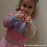 child, girl, bow, pastel_sweater, pink_skirt, wall, indoor, portrait, cute, smile, long_hair, fashion, clothing, playful, young, person, childhood, apparel, standing, posing