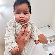 Riantsoa a rejoint le concours — aidez-le/la à gagner de superbes lots ! baby, infant, child, hand, adult, person, indoor, kitchen, clothing, onesie, face, hair, expression, holding, portrait, cute, young, skin, fingers, light