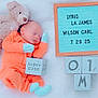 newborn, baby, sleeping, teddy_bear, orange_outfit, mittens, booties, letter_board, blocks, name_board, soft_blanket, cute, infant, portrait, resting, child, indoors, baby_clothes, peaceful, toy