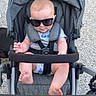 baby, casual_clothing, child, cute, fashion, feet, grass, gravel, hands, head, infant, outdoor, person, relaxing, seatbelt, shade, stroller, summer, sunglasses, sunny