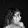 child, curly_hair, black_and_white, portrait, indoor, thoughtful, young, face, expression, person, hair, skin, bare_chest, profile, hand, fingertip, wall, decoration, shadow, monochrome