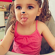 Serena participe au concours pour gagner de l'argent avec cette photo : child, toddler, girl, high_chair, pink_tank_top, curly_hair, pigtails, playful, sticking_tongue_out, face_filter, animal_ears, animal_nose, sparkles, indoor, kitchen, furniture, smile, cute, portrait, person