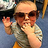 Brooks Bennett joined the competition — help win amazing prizes! toddler, child, sunglasses, indoor, carpet, sitting, hand, fingers, clothing, striped_shirt, orange_pants, face, cute, snack, toy, chair, background, baby, playtime, casual