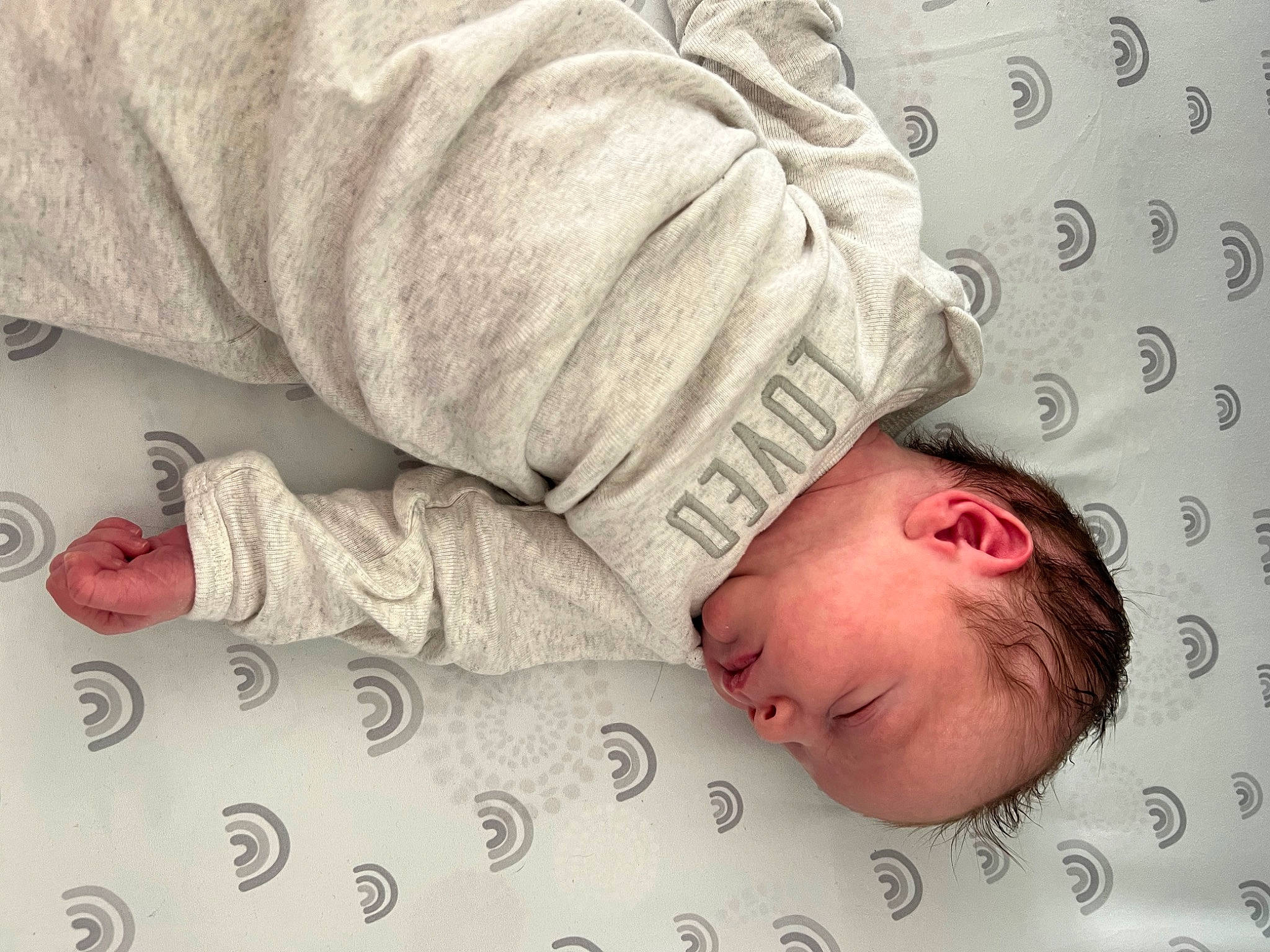 Niko is registered to the contest to win money with this photo: arm, baby, baby_products, baby_sleeping, baby_toddler_clothing, bed, bedding, bedtime, child, comfort, hand, linens, nap, pattern, person, room, skin, sleep, sleeve, textile