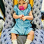 Romy participe au concours pour gagner de l'argent avec cette photo : baby, infant, pacifier, headband, bow, romper, socks, baby_seat, patterned_fabric, indoor, child, cute, comfort, person, young_child, clothing, portrait, sitting, closeup, colorful