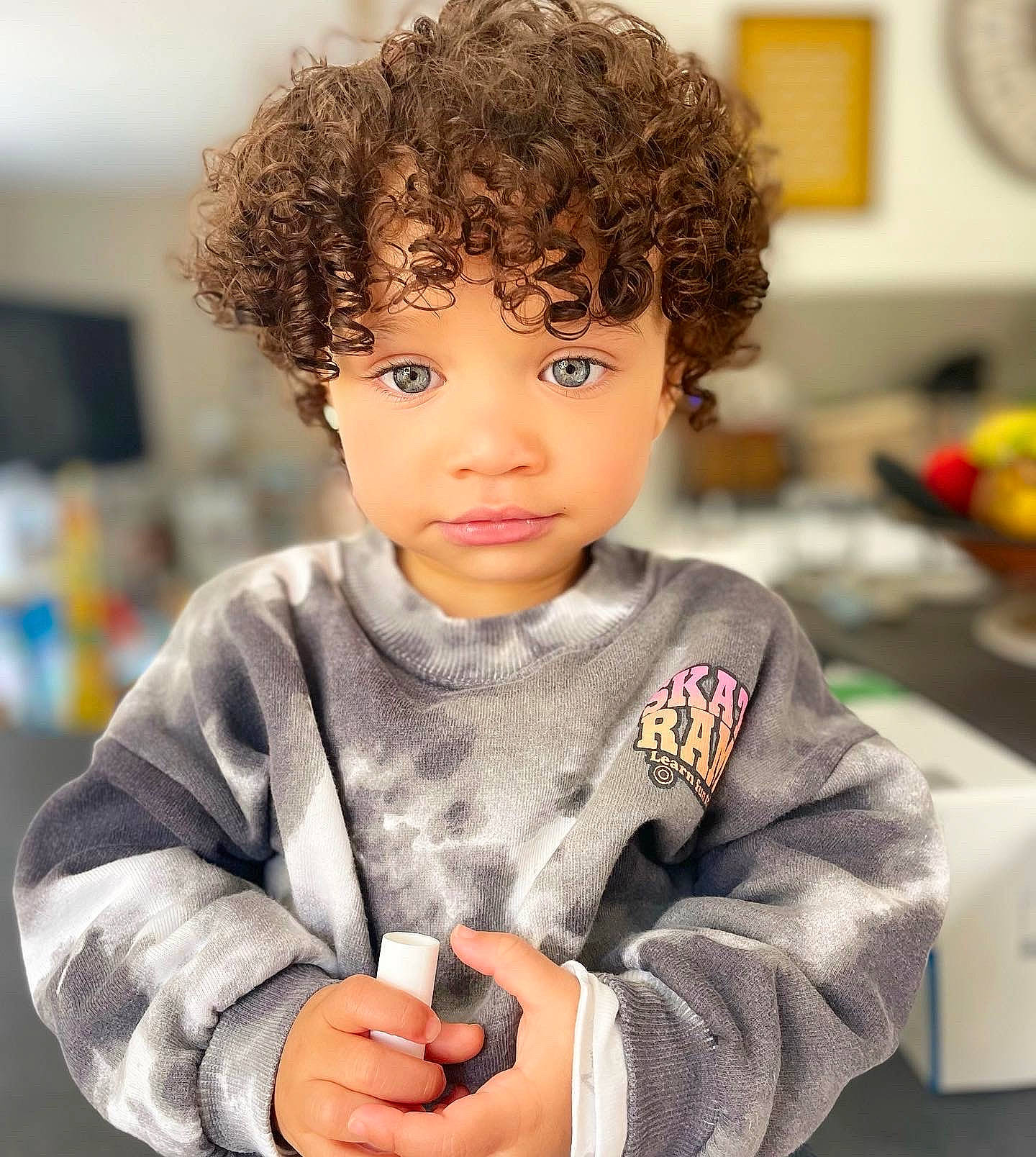 Nell participe au concours pour gagner de l'argent avec cette photo : afro, brown_hair, cheek, child, chin, eye, fashion_design, forehead, fun, gesture, happy, jheri_curl, person, ringlet, room, sitting, skin, sleeve, toddler, toy