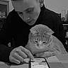 cat, person, smartphone, table, indoor, black_sweater, curious_cat, young_man, technology, pet, interaction, looking_down, short_hair, domestic_animal, furniture, monochrome, focused, hand, screen, home