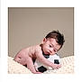 adorable, baby, child, cute, hair, head, hugging, indoors, infant, lying_down, neutral_background, plush_toy, portrait, resting, skin, small, soccer_ball, soft_blanket, toddler, young