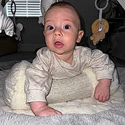 Tommy is registered to the contest to win money with this photo: baby, blanket, child, clothing, curious, cushion, expression, face, floor, hand, home, indoor, infant, light, person, play_gym, plush_toy, soft_texture, wide_eyes, window_blinds