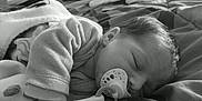 Léonie a rejoint le concours — aidez-le/la à gagner de superbes lots ! baby, bed, blanket, child, clothing, comfort, cozy, cute, face, hair, indoors, infant, monochrome, pacifier, peaceful, portrait, resting, sleeping, soft_toy, young_child