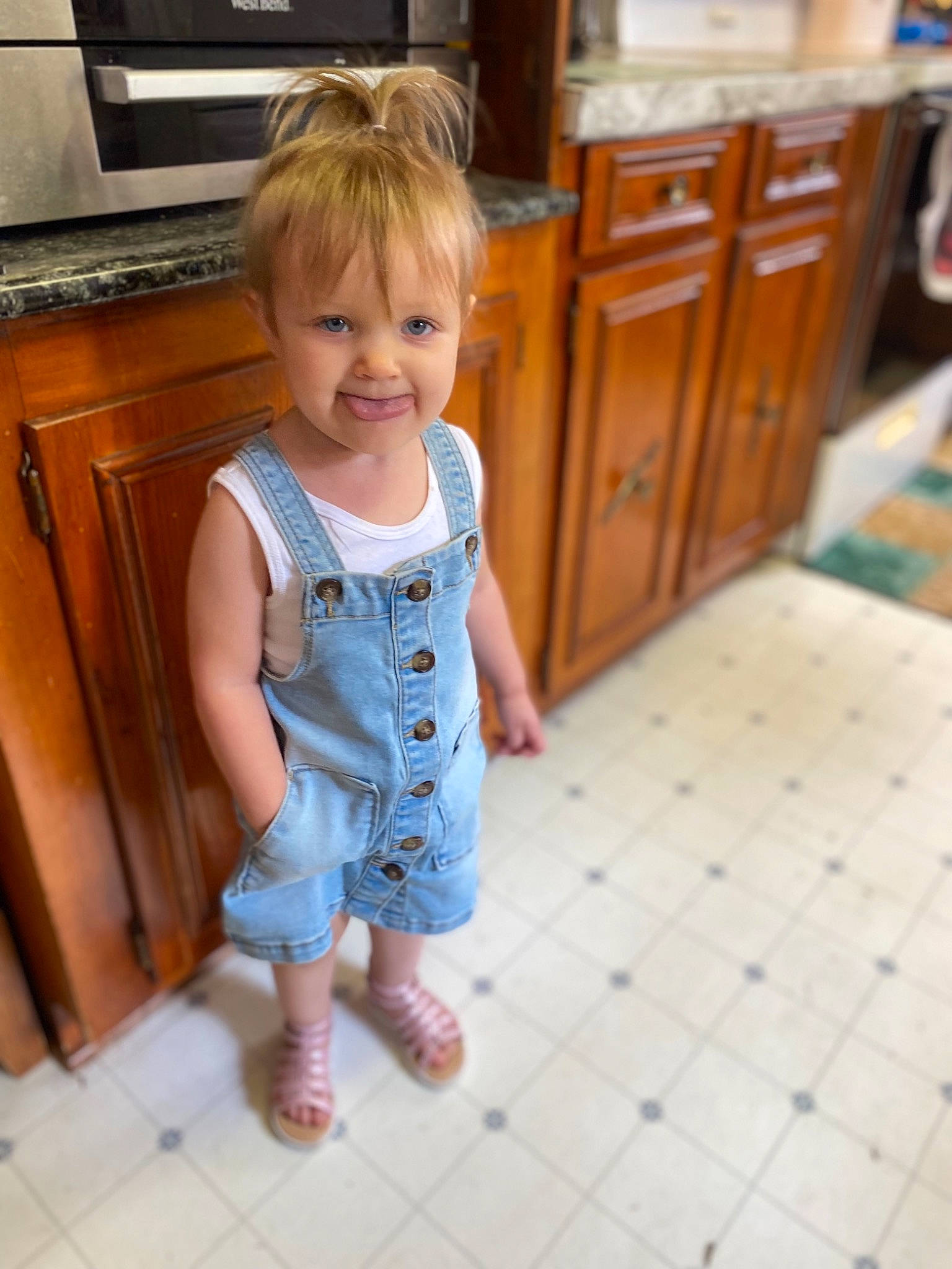 Brayleigh is registered to the contest to win money with this photo: baby_toddler_clothing, cabinetry, child, drawer, dress, floor, flooring, hair, hardwood, head, jeans, joint, joy, person, shoulder, skin, sleeve, smile, standing, t_shirt