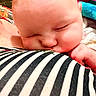 Hope is registered to the contest to win money with this photo: baby, blanket, cheek, child, close_up, comfort, cute, face, hand, indoors, infant, newborn, peaceful, person, portrait, rest, skin, sleeping, soft, striped_clothing