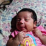 Miracle Maya joined the competition — help win amazing prizes! baby, newborn, infant, pink_clothing, rainbow, floral_bedspread, hand_gesture, cute, lying_down, indoors, portrait, child, person, soft_light, small_hands, sleepy_eyes, colorful, fabric, closeup, happy