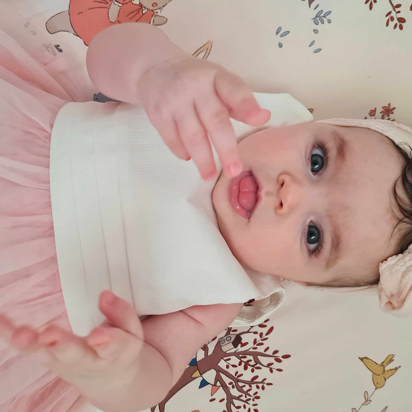 Kayla a rejoint le concours — aidez-le/la à gagner de superbes lots ! baby, blanket, blue_eyes, child, cute, dress, expression, face, hand, headband, indoors, infant, laying_down, pattern, pink, portrait, reaching, skin, tulle, young