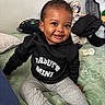 toddler, child, smile, black_hoodie, daddys_mini, gray_pants, red_slippers, baby_bottle, pillow, blanket, indoor, cute, happy, sitting, face, person, home, cozy, clothing, infant