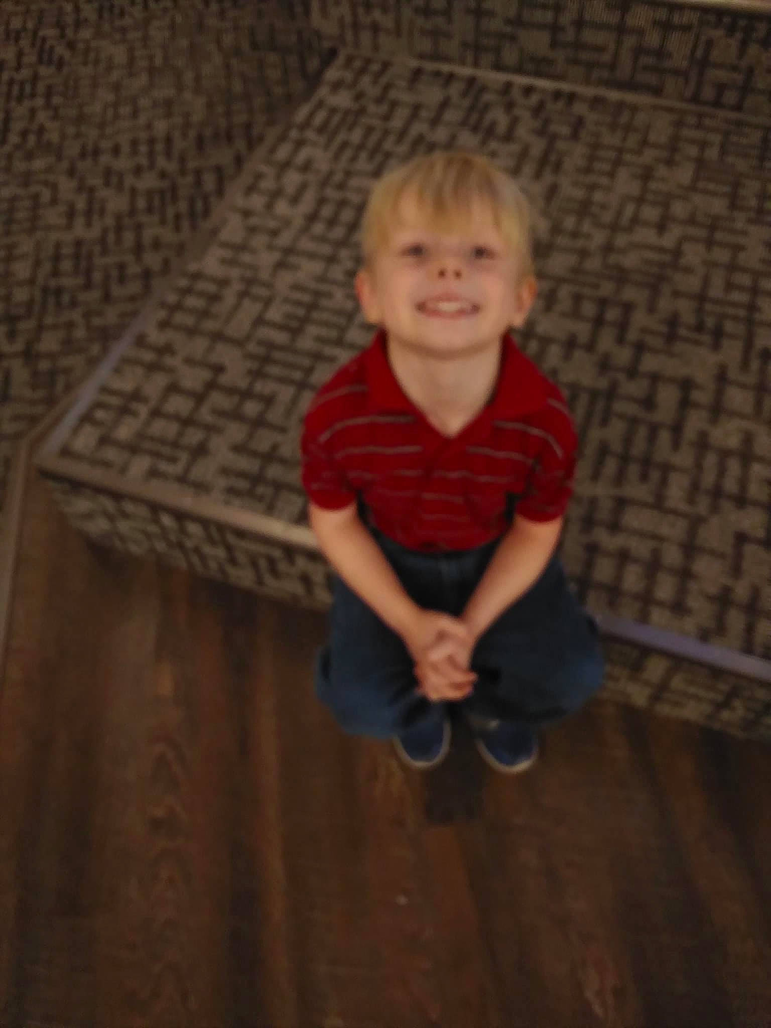 Aidan is registered to the contest to win money with this photo: cheek, child, floor, flooring, fun, hardwood, joy, person, photography, portrait, sitting, smile, standing, toddler, wood