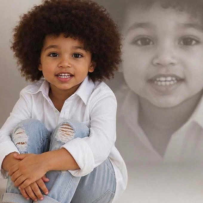 Devonta joined the competition — help win amazing prizes! child, portrait, smiling, curly_hair, sitting, barefoot, white_shirt, jeans, fashion, studio, indoor, backdrop, double_exposure, faded_portrait, closeup, casual, happy, person, photography, creative_composition