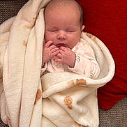 Darcie-Rose joined the competition — help win amazing prizes! baby, blanket, sleeping, infant, couch, red_cushion, soft_texture, hands, face, peaceful, cozy, wrapped, newborn, cute, portrait, indoors, resting, comfort, warm, relaxation