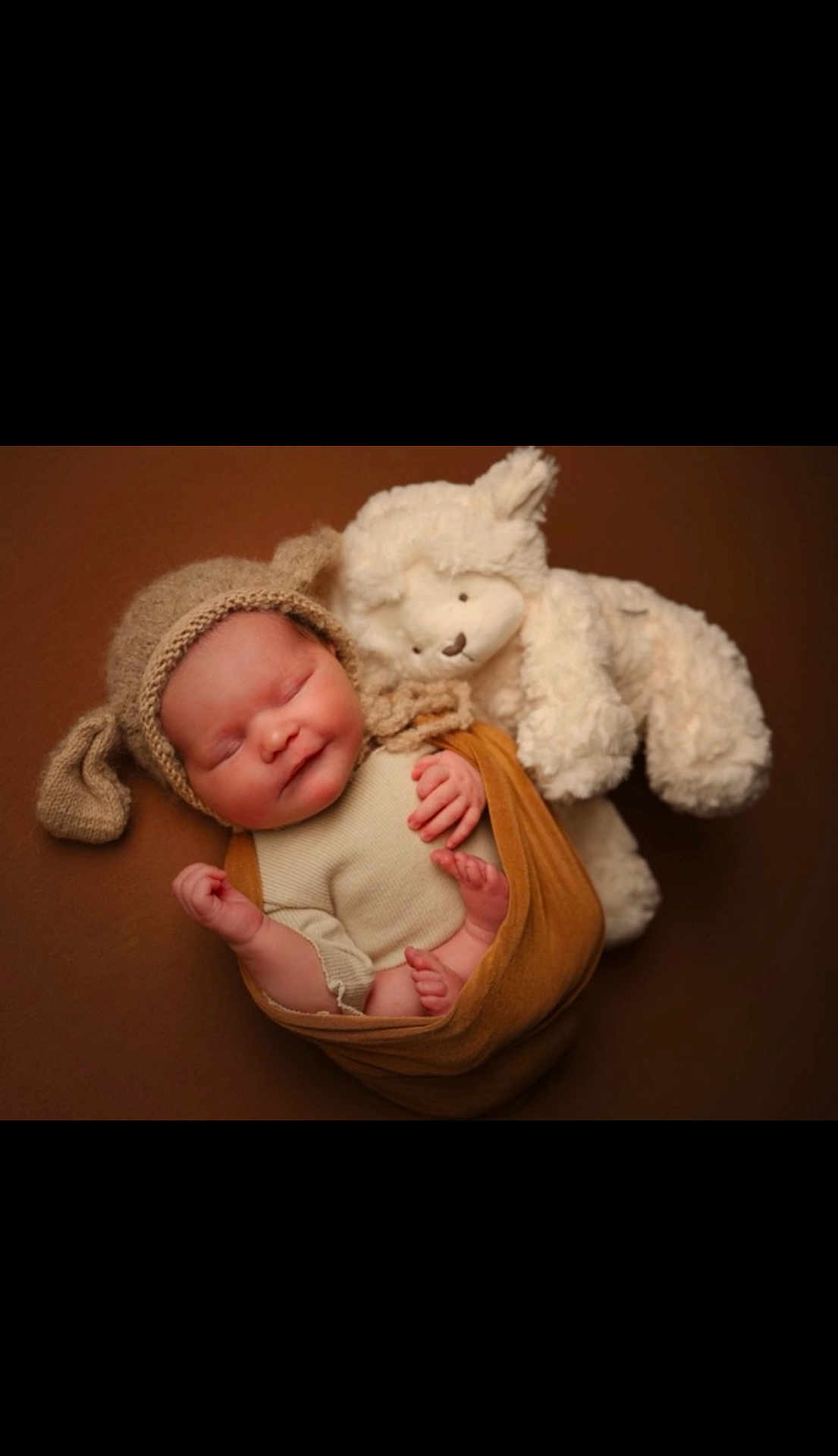 Darcie-Rose joined the competition — help win amazing prizes! newborn, baby, sleeping, knitted_hat, floppy_ears, teddy_bear, soft_toy, wrapped, brown_background, cute, infant, cozy, portrait, child, peaceful, cuddly, warm_colors, indoors, resting, adorable